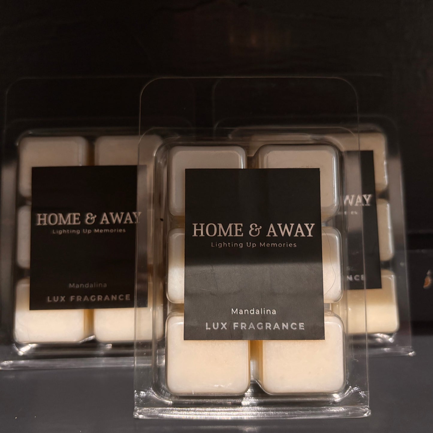 Packaged wax melts with 'Home & Away' branding on a dark background