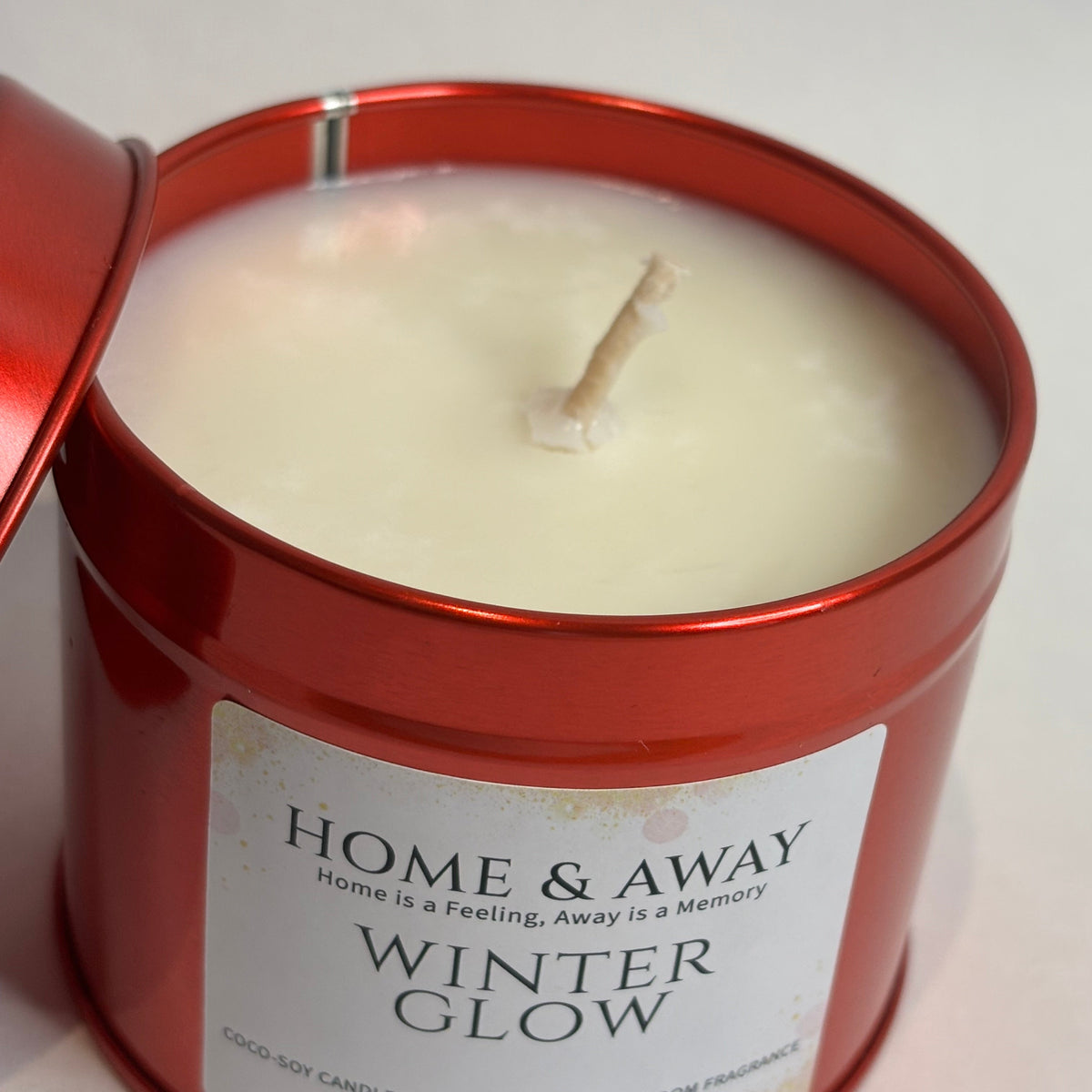 Winter Glow Christmas candle in a glossy red tin, hand-poured by Home & Away Candles