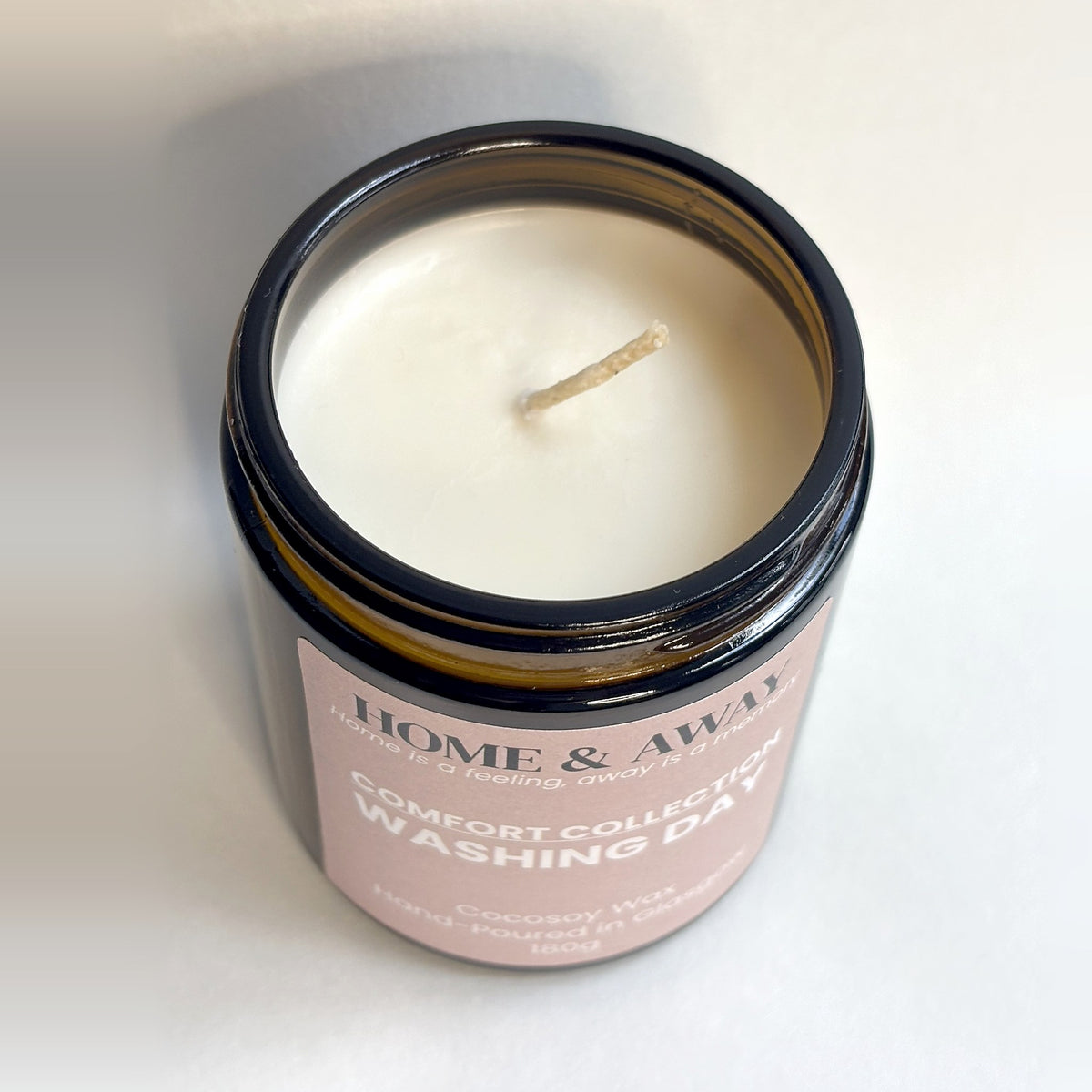 Washing Day candle from the Comfort Collection in an amber glass jar with a black lid, hand-poured by Home & Away Candles