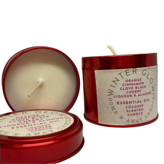 Red candle tin with a lit candle inside, featuring a label on a white background