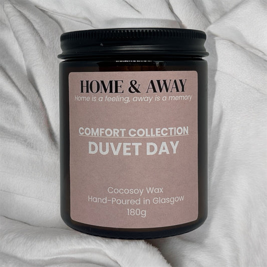 Duvet Day candle from the Comfort Collection in an amber glass jar with a black lid, hand-poured by Home & Away Candles