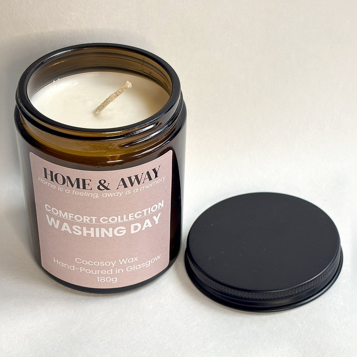 Washing Day candle from the Comfort Collection in an amber glass jar with a black lid, hand-poured by Home & Away Candles